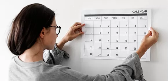 Cronograma impresso organizando um plano de estudos de inglês para concursos sobre uma mesa de trabalho.